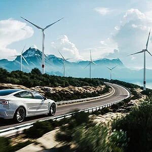 Electric car drive on the wind turbines background